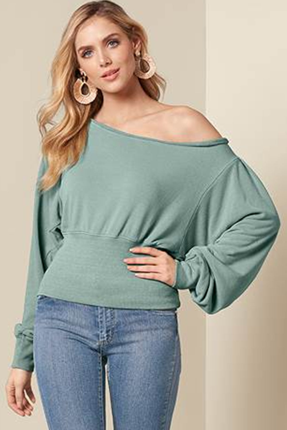 A stylish green off shoulder blouse with bishop sleeves and a cinched waist, perfect for winter fashion.