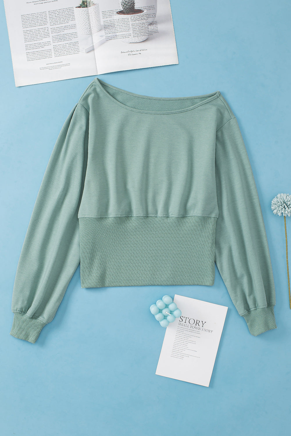 A stylish green off shoulder blouse with bishop sleeves and a cinched waist, perfect for winter fashion.