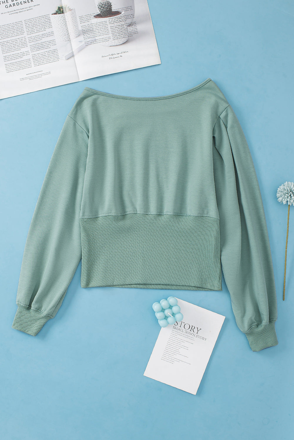 A stylish green off shoulder blouse with bishop sleeves and a cinched waist, perfect for winter fashion.