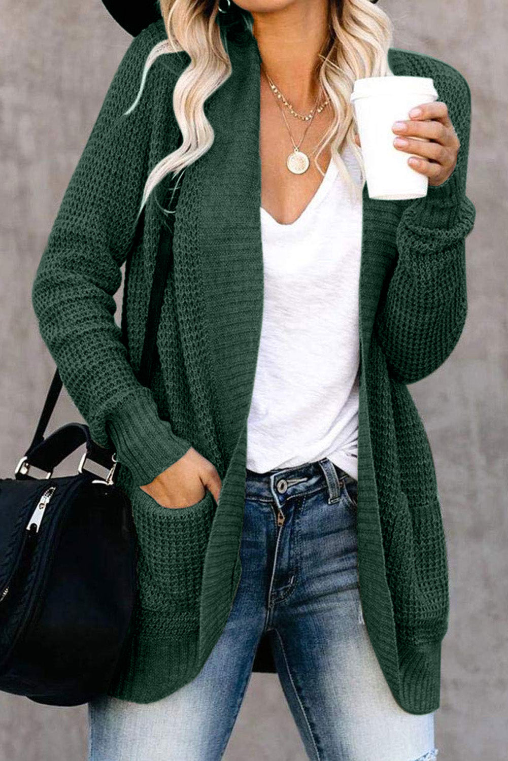 A stylish green pocket knitted solid color cardigan with a fuzzy texture and arc-shaped hem design, perfect for casual wear.