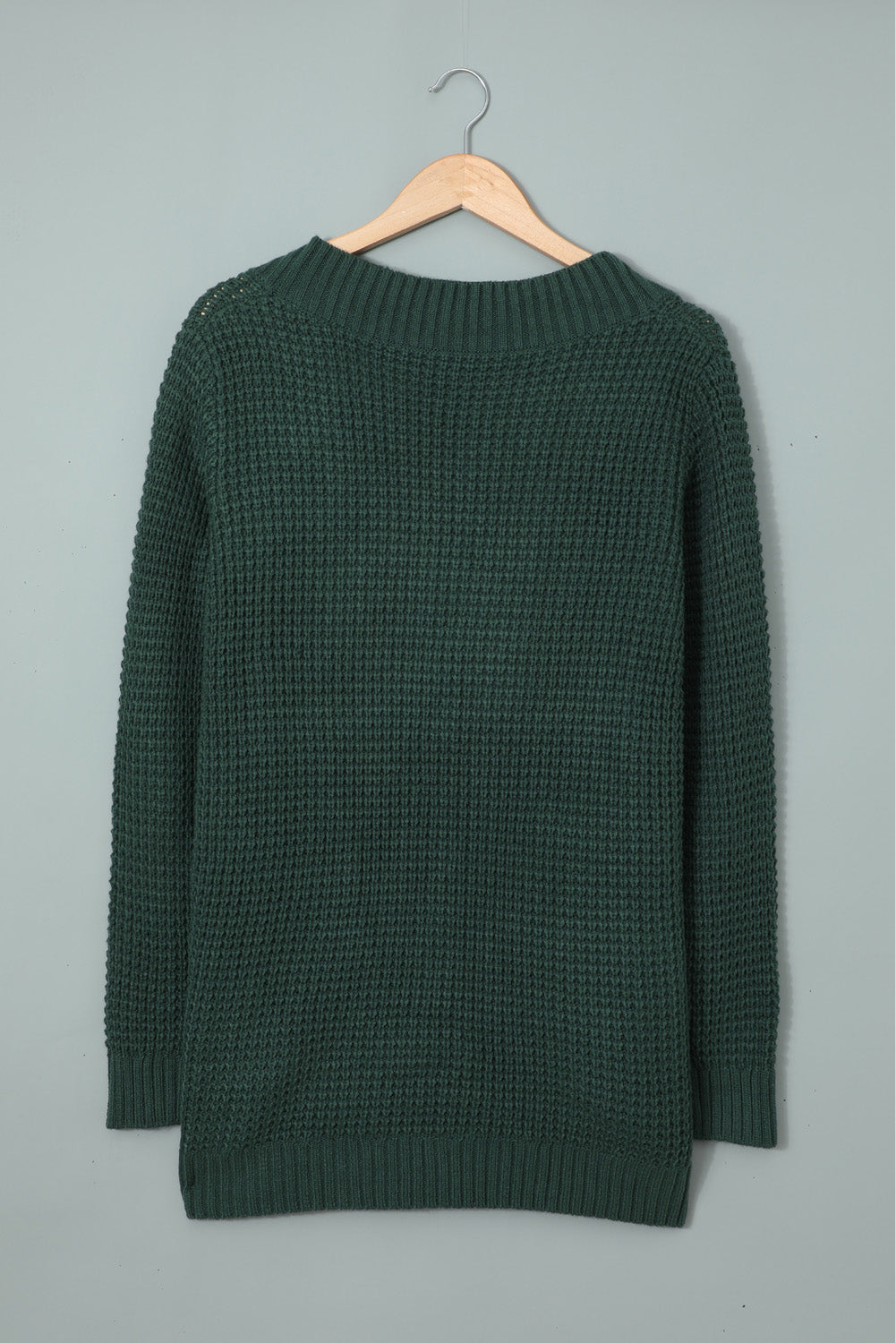 A stylish green pocket knitted solid color cardigan with a fuzzy texture and arc-shaped hem design, perfect for casual wear.