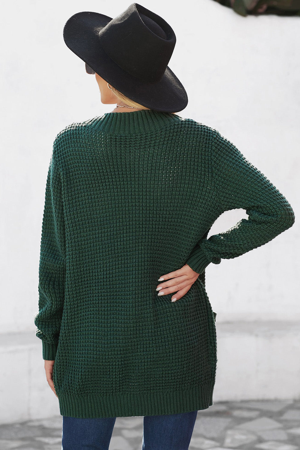 A stylish green pocket knitted solid color cardigan with a fuzzy texture and arc-shaped hem design, perfect for casual wear.