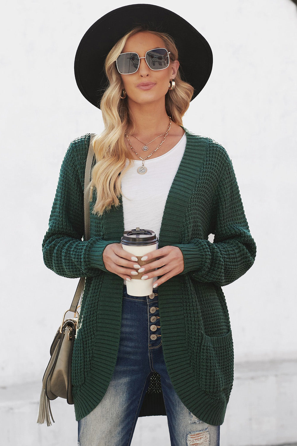 A stylish green pocket knitted solid color cardigan with a fuzzy texture and arc-shaped hem design, perfect for casual wear.