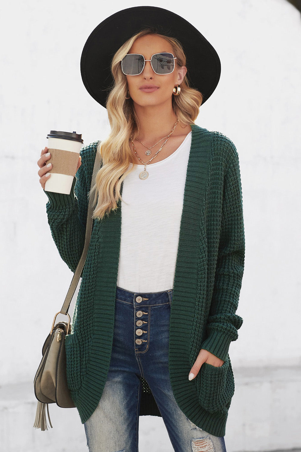 A stylish green pocket knitted solid color cardigan with a fuzzy texture and arc-shaped hem design, perfect for casual wear.