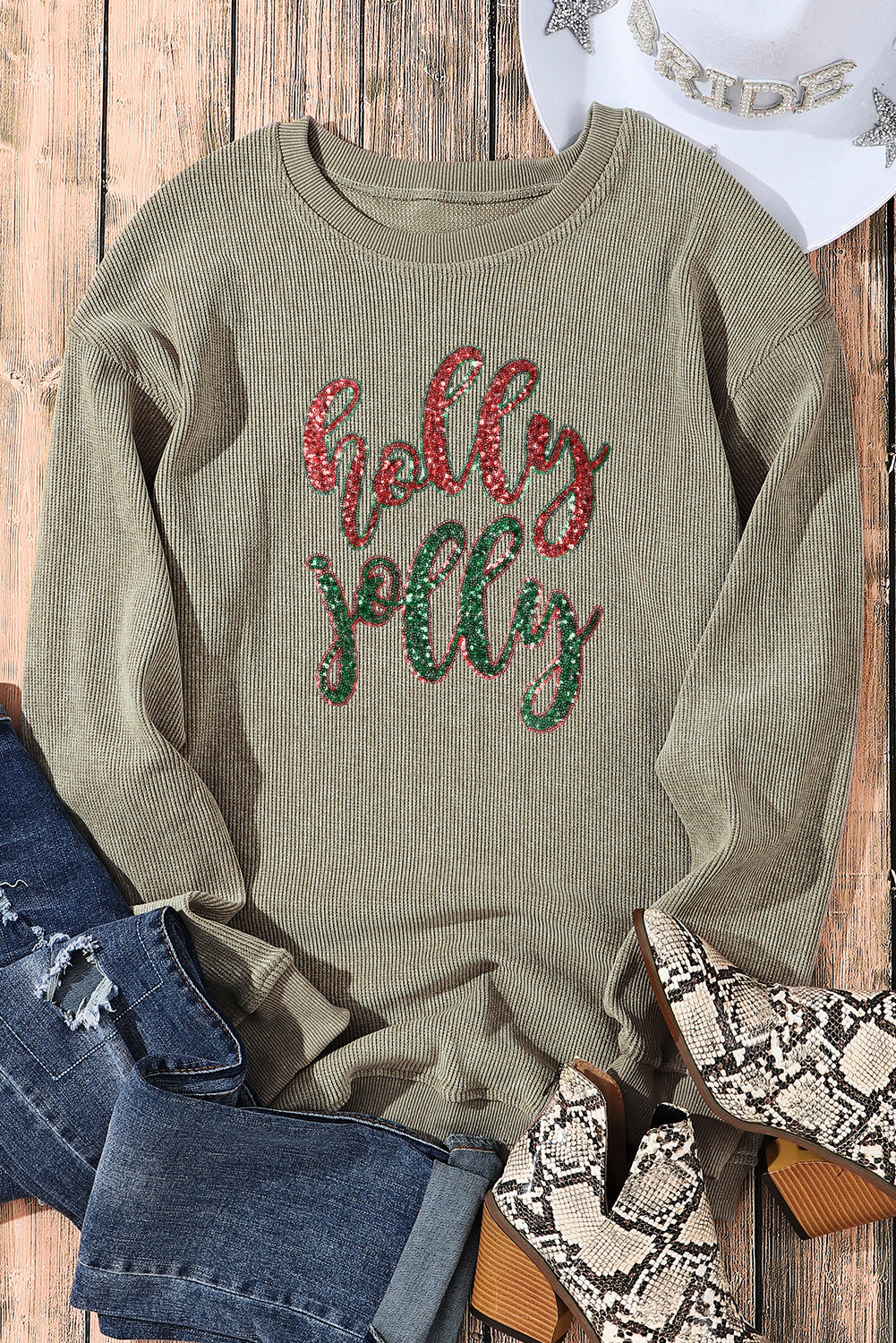 A vibrant green corded sweatshirt featuring a sequined 'holly jolly' graphic, perfect for festive occasions.