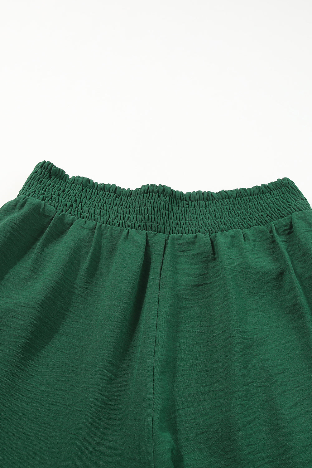 A stylish green square neck smocked peplum top paired with loose high waist pants, showcasing a feminine and elegant look.