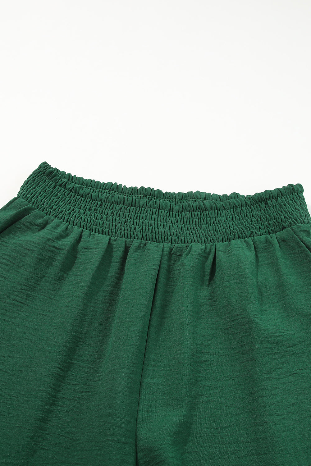 A stylish green square neck smocked peplum top paired with loose high waist pants, showcasing a feminine and elegant look.