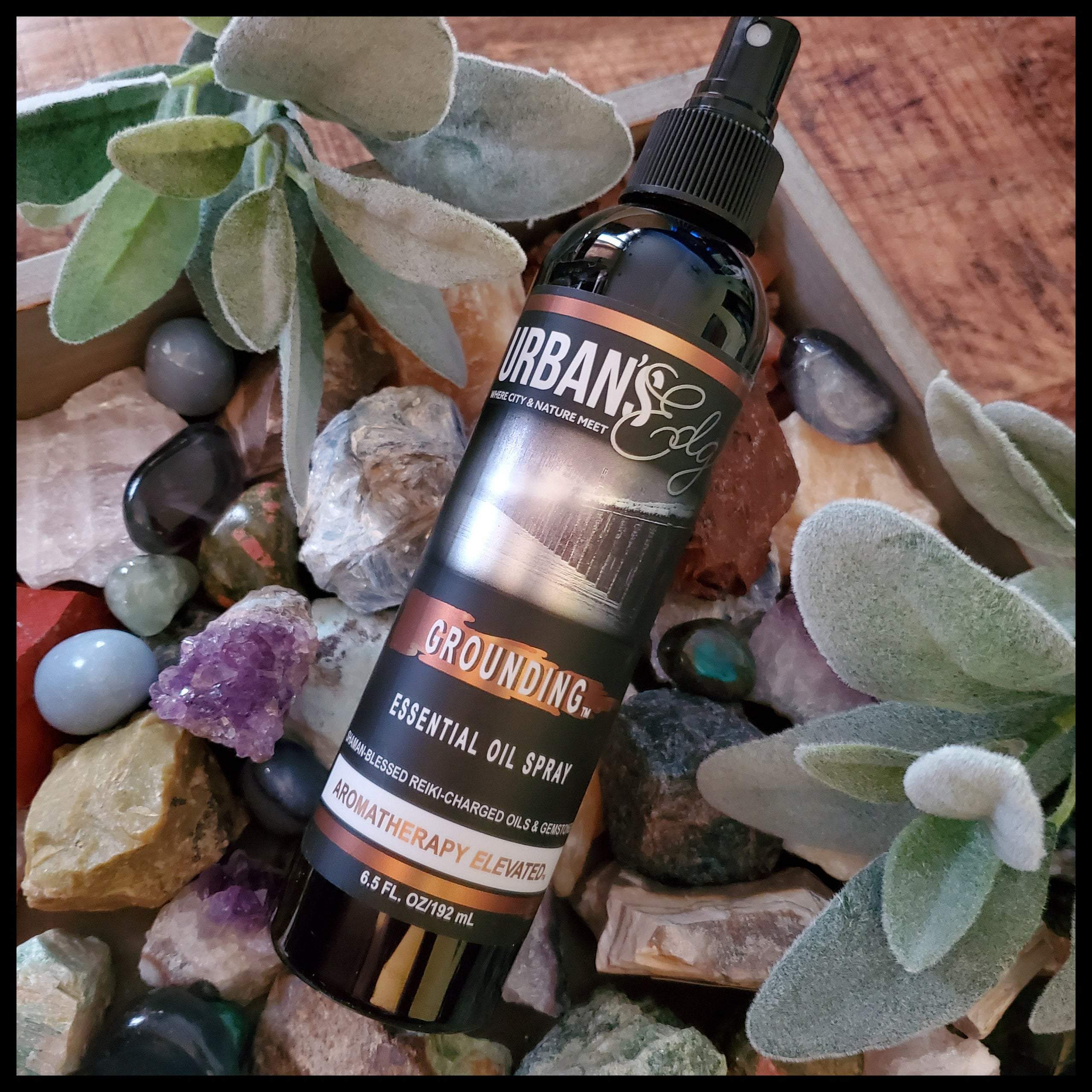 Grounding Essential Oil Spray bottle with a mist, featuring natural ingredients and gemstones for holistic healing.