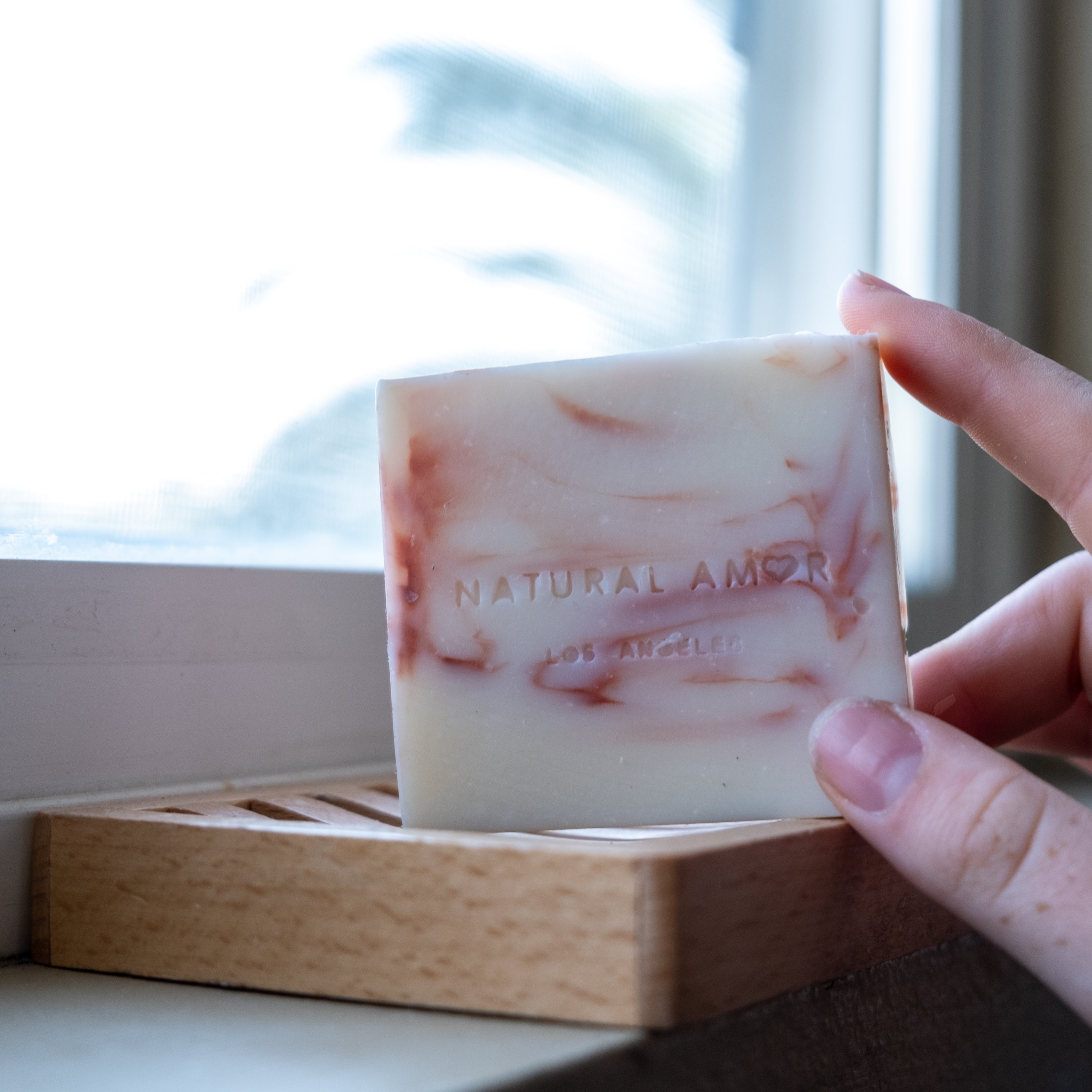 Set of three handmade vegan soaps in lavender, rose, and citrus scents, beautifully packaged.