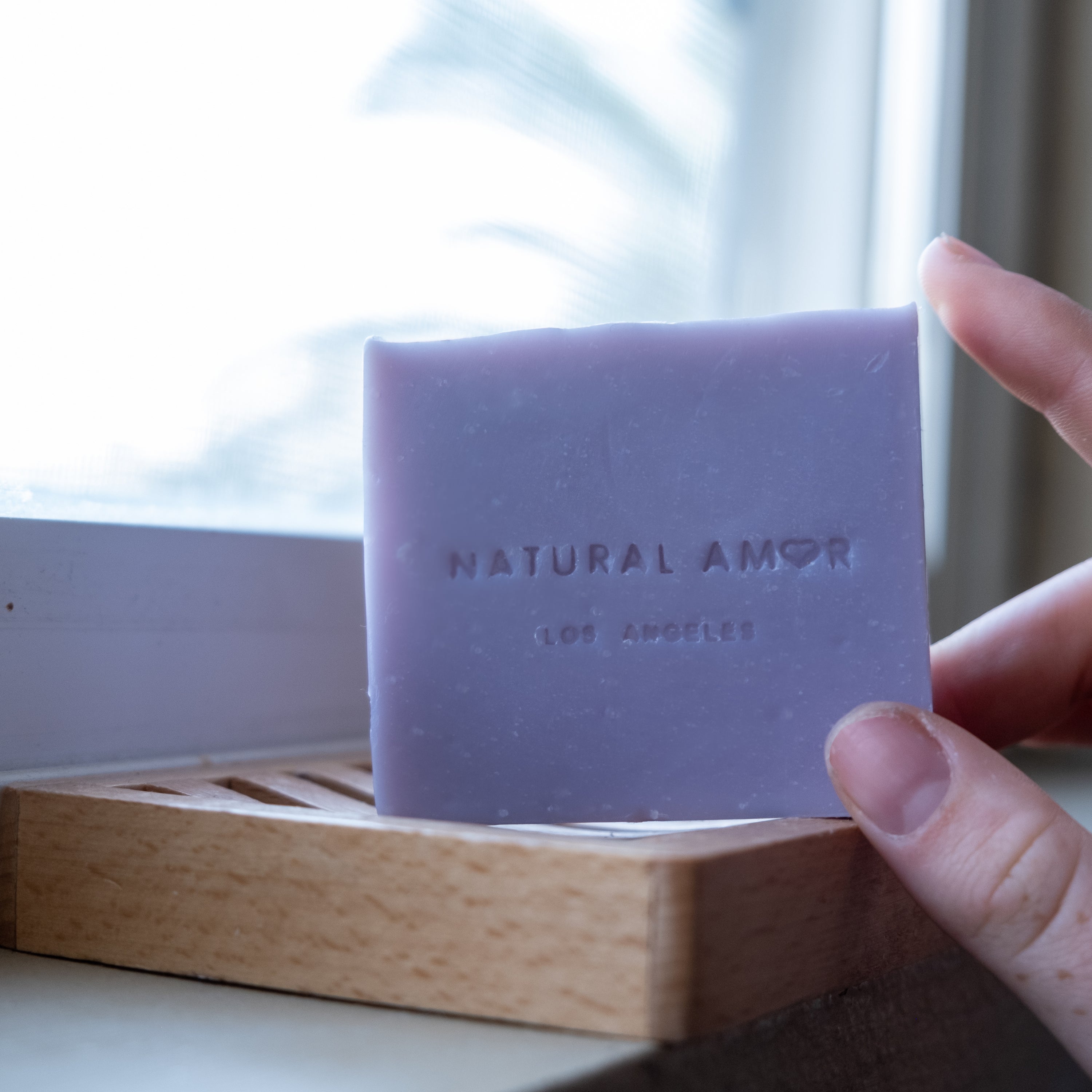 Set of three handmade vegan soaps in lavender, rose, and citrus scents, beautifully packaged.