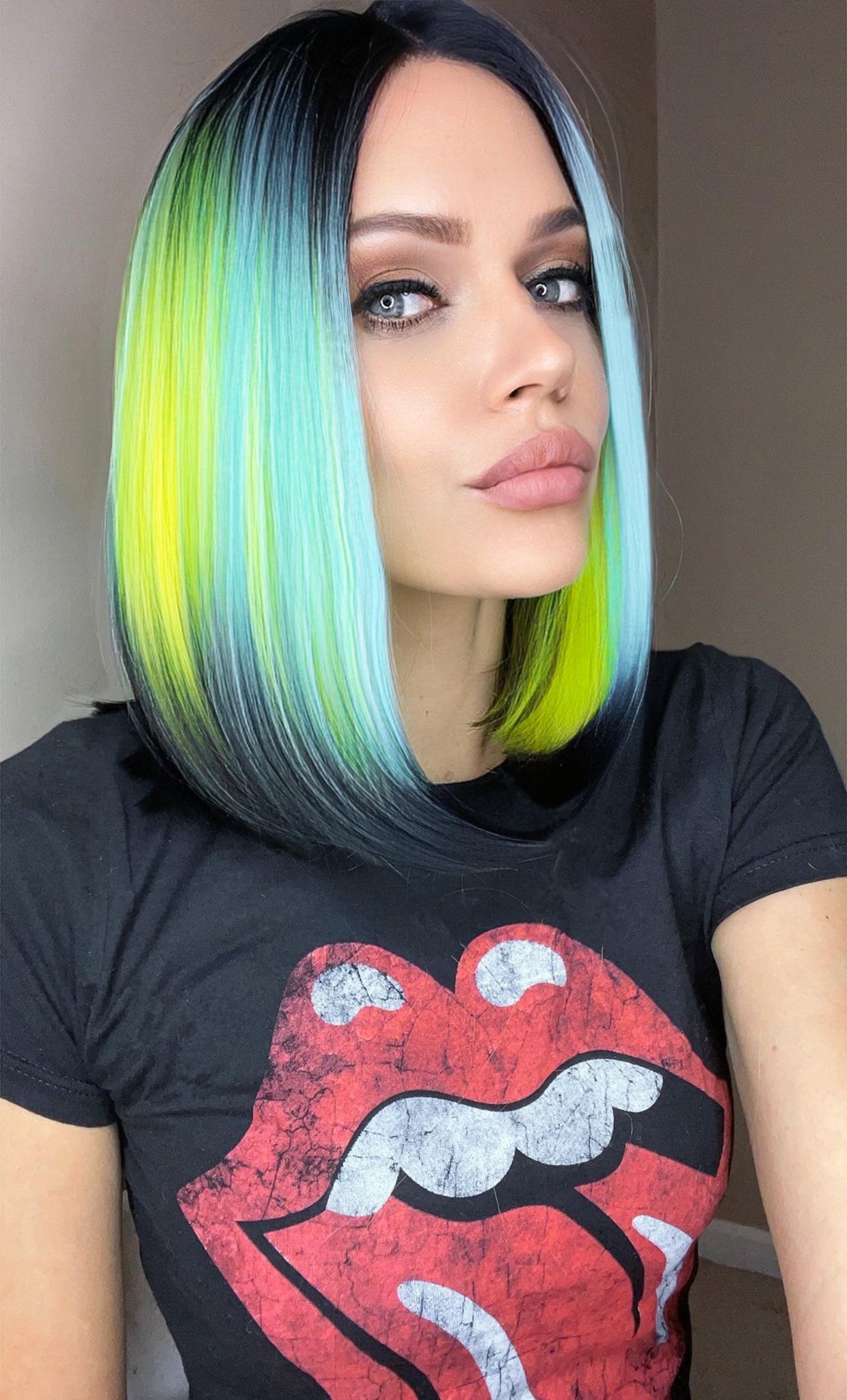 Heidi Tropical wig featuring vibrant ombre teal and yellow colors with black roots and tips, styled on a mannequin.