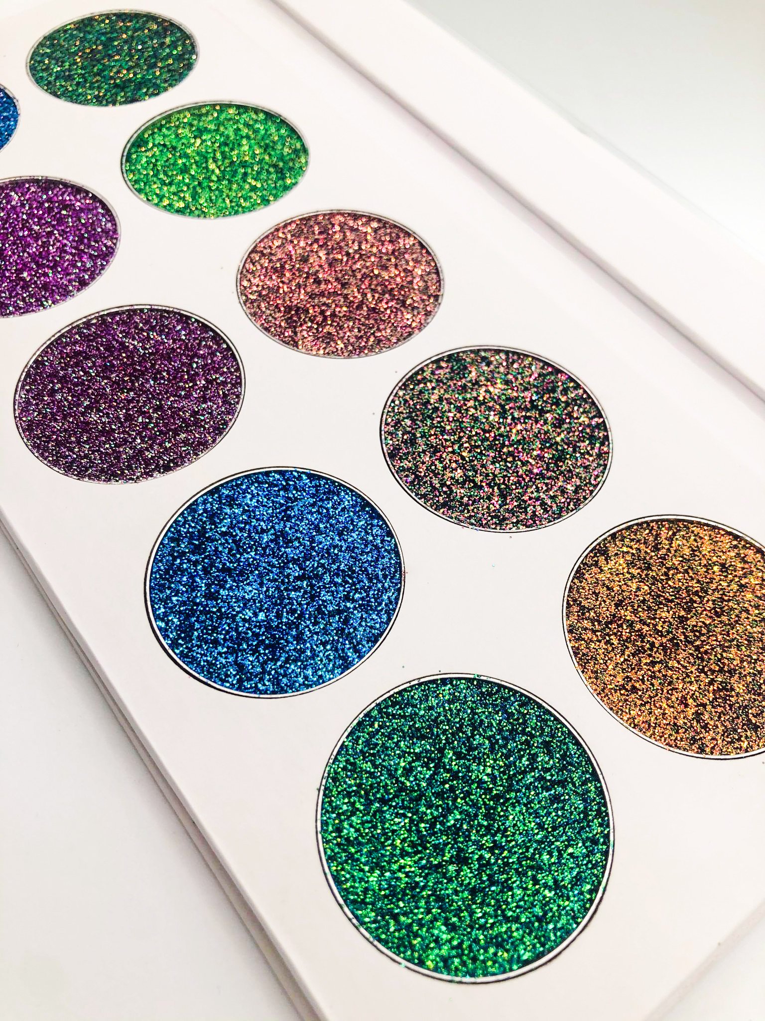 Inspire Palette featuring multichromatic glitter pigments in vibrant colors, arranged in 36mm pans, showcasing a variety of shades for creative makeup looks.