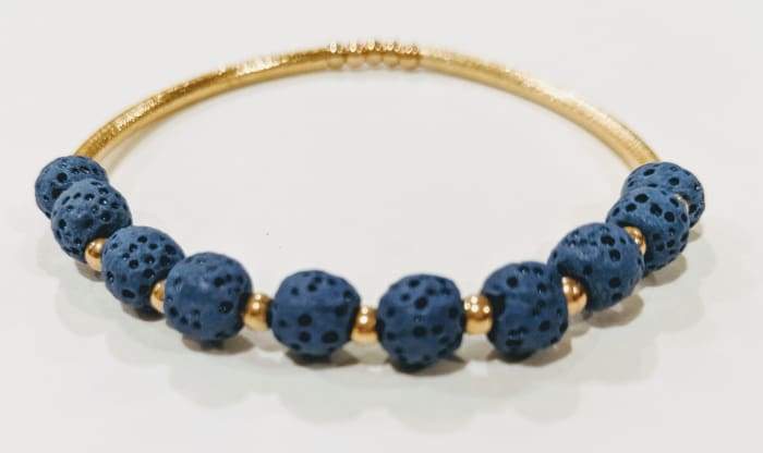 Dark blue lava stone essential oil bracelet with gold accents, showcasing its stylish design and natural texture.