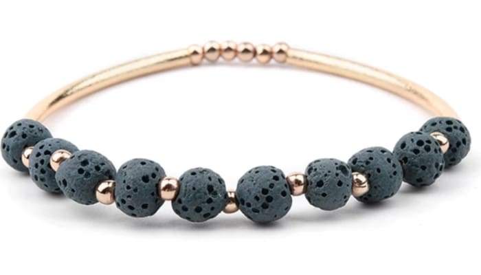 Dark green lava stone essential oil bracelet with gold accents, showcasing its natural texture and elegant design.