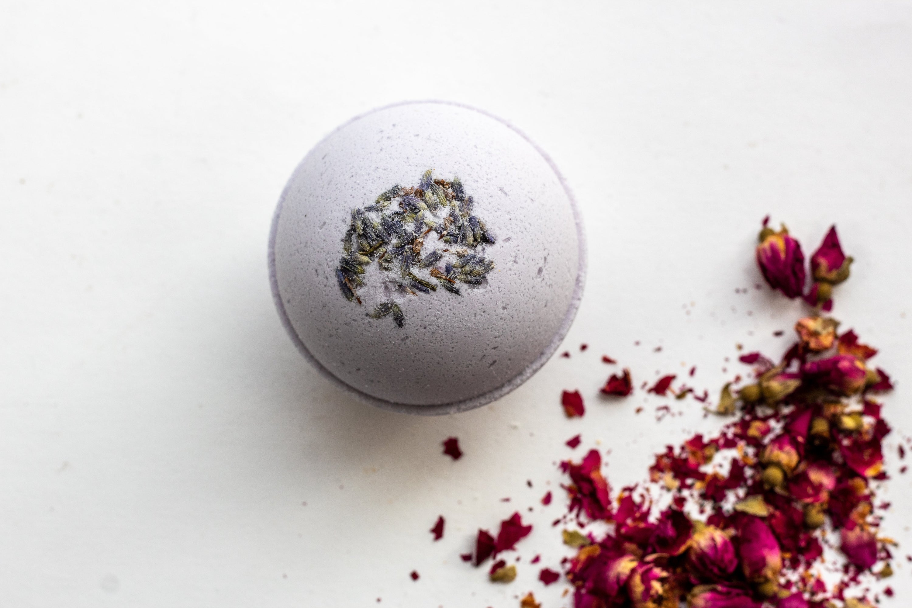 Lavender Bergamot Bath Bomb with flower petals, showcasing its vibrant color and organic ingredients.