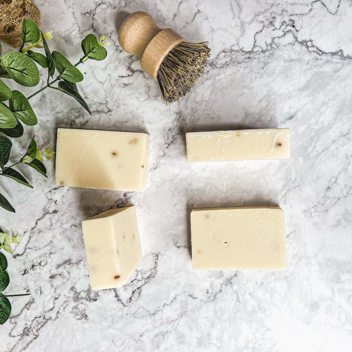 A handcrafted bar of Lavender Ylang Ylang soap featuring lavender buds and a blend of natural oils, showcasing its unique design and texture.