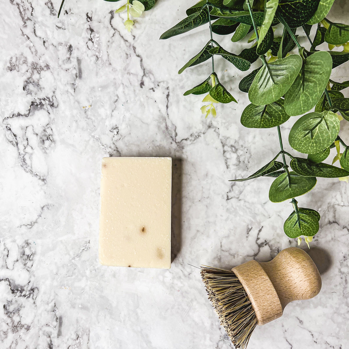 A handcrafted bar of Lavender Ylang Ylang soap featuring lavender buds and a blend of natural oils, showcasing its unique design and texture.