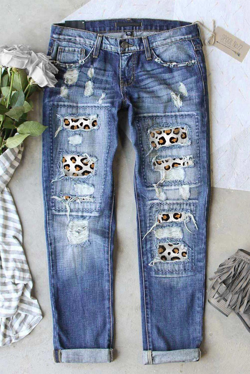 A pair of stylish leopard print ripped jeans featuring distressed patches and a high waist design, perfect for casual wear.