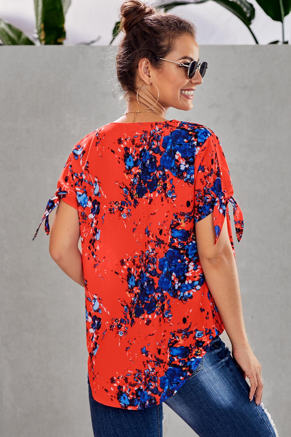 Leopard V Neck Twist Top featuring a floral print, short sleeves with slits and ties, and a stylish surplice neckline.