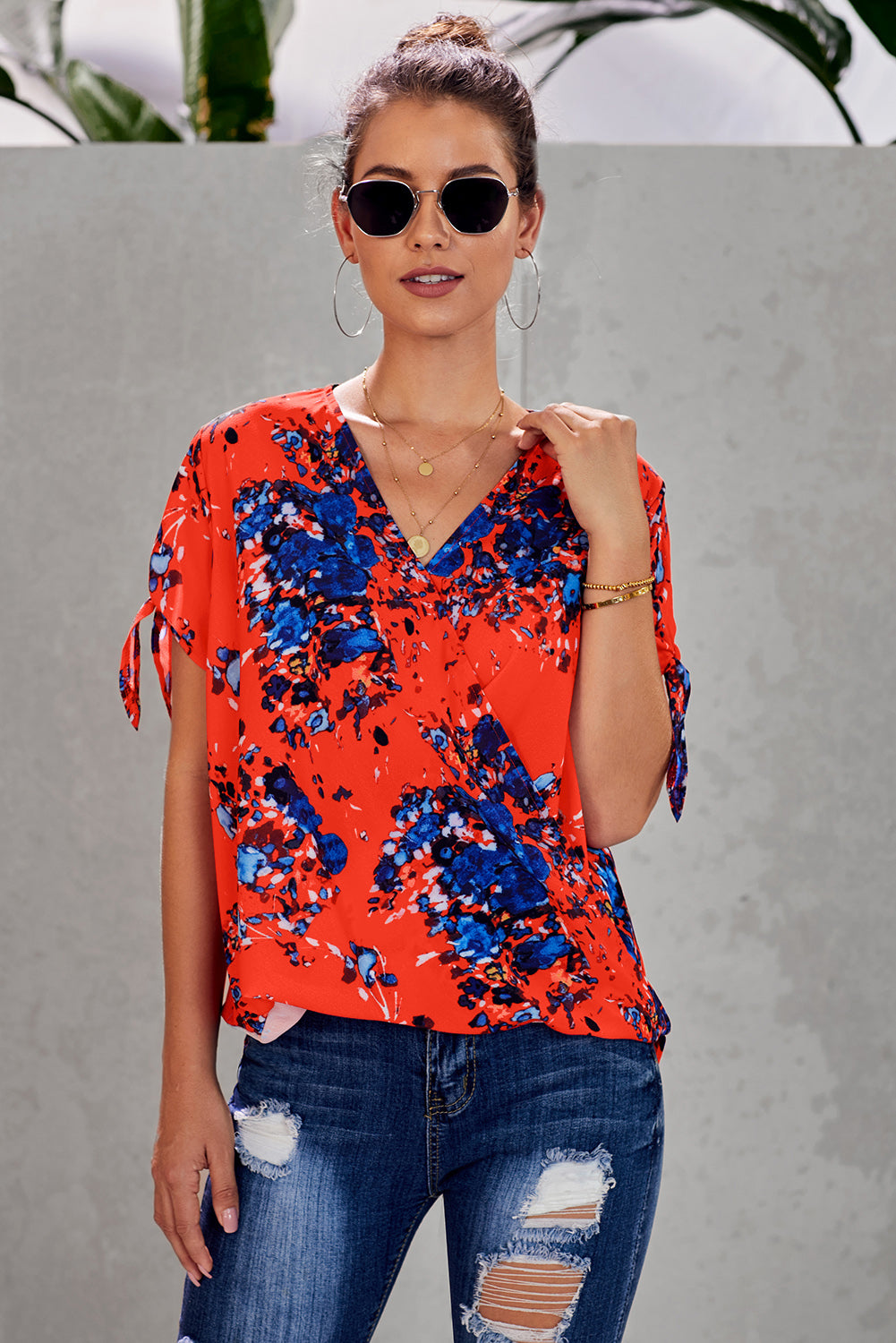 Leopard V Neck Twist Top featuring a floral print, short sleeves with slits and ties, and a stylish surplice neckline.