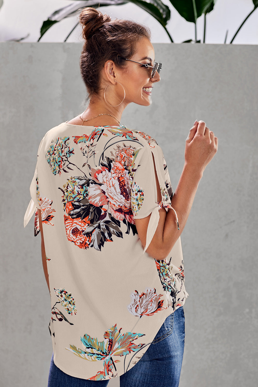 Leopard V Neck Twist Top featuring a floral print, short sleeves with slits and ties, and a stylish surplice neckline.