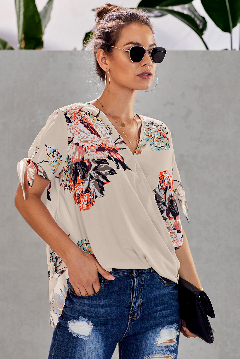 Leopard V Neck Twist Top featuring a floral print, short sleeves with slits and ties, and a stylish surplice neckline.