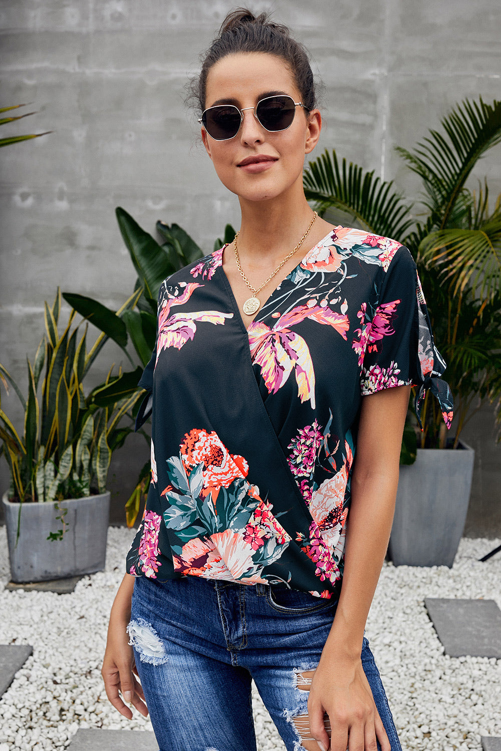 Leopard V Neck Twist Top featuring a floral print, short sleeves with slits and ties, and a stylish surplice neckline.