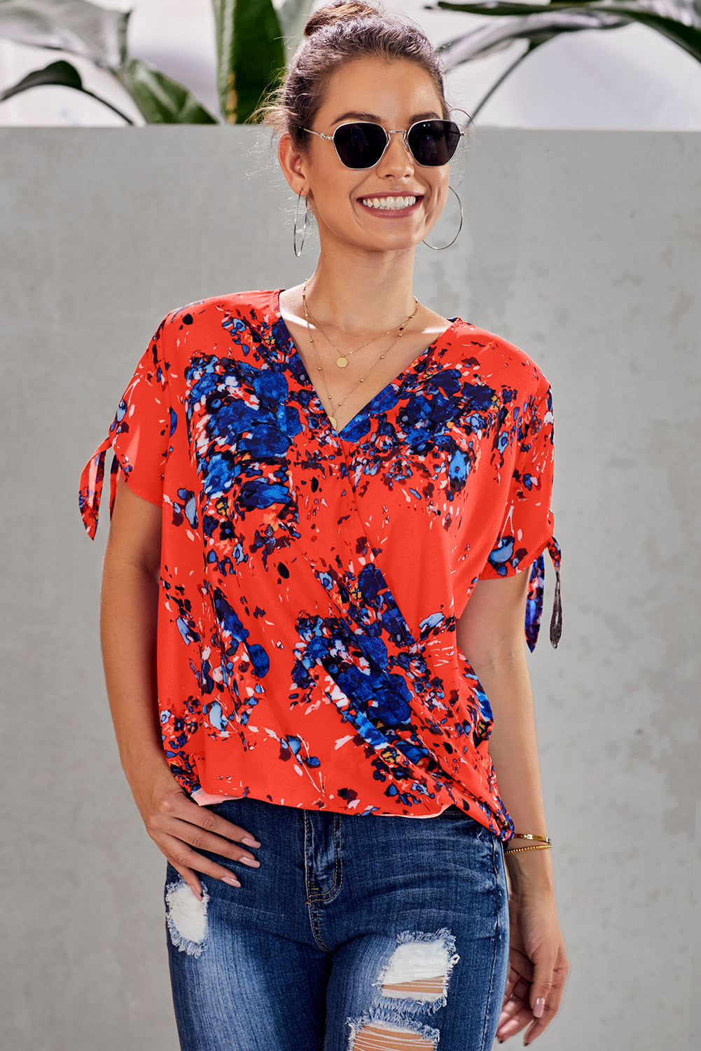 Leopard V Neck Twist Top featuring a floral print, short sleeves with slits and ties, and a stylish surplice neckline.