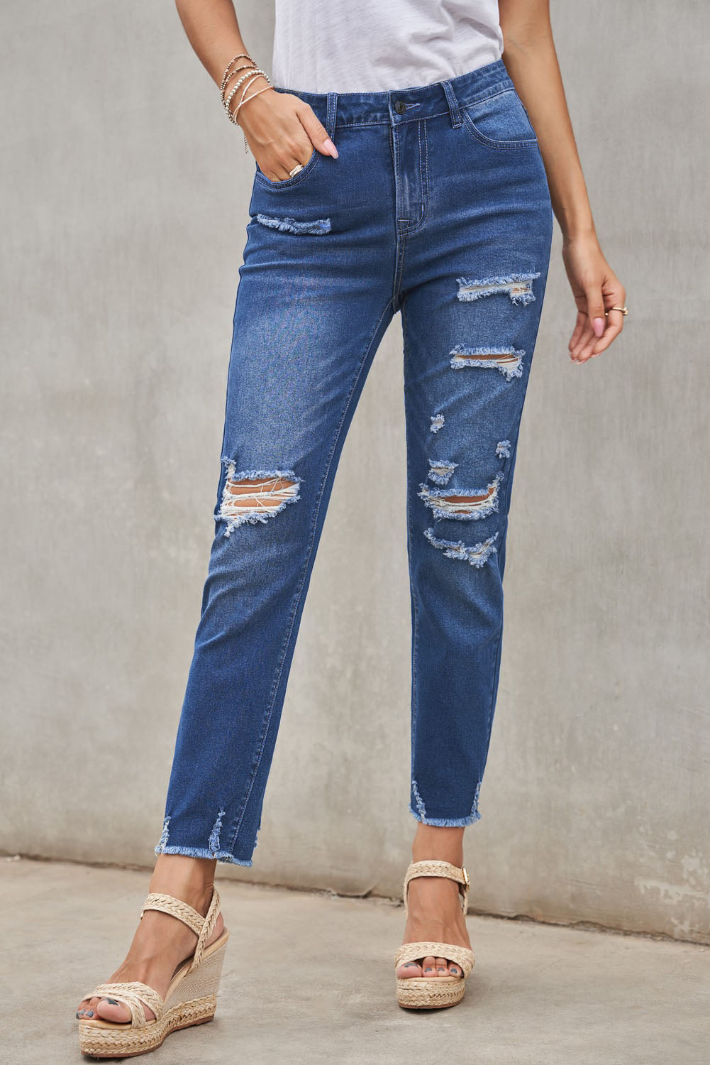 Light blue distressed boyfriend denim pants with a medium rise fit and straight leg silhouette, featuring classic five-pocket styling.