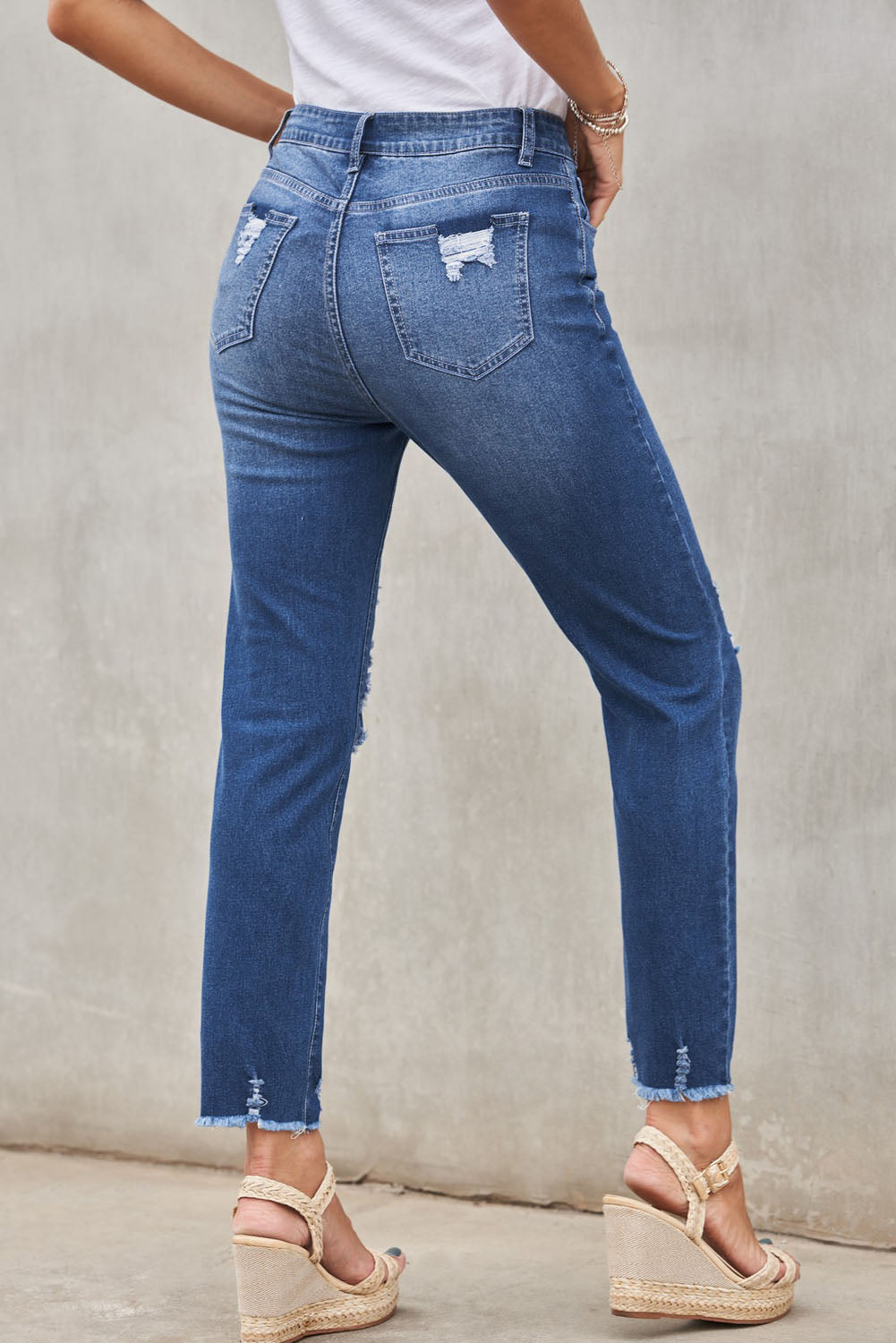 Light blue distressed boyfriend denim pants with a medium rise fit and straight leg silhouette, featuring classic five-pocket styling.