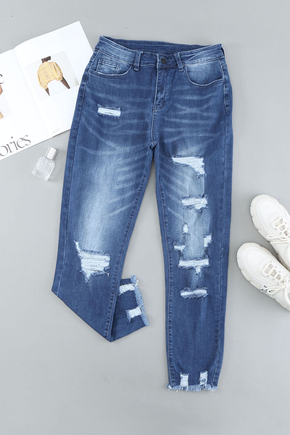 Light blue distressed boyfriend denim pants with a medium rise fit and straight leg silhouette, featuring classic five-pocket styling.