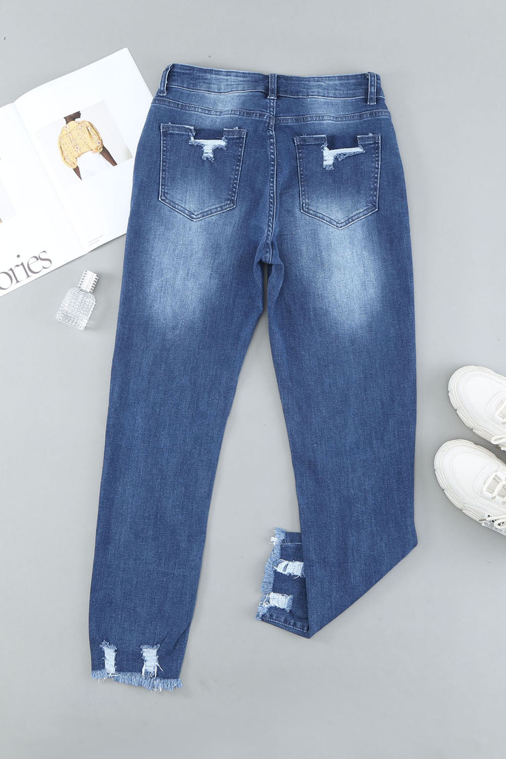 Light blue distressed boyfriend denim pants with a medium rise fit and straight leg silhouette, featuring classic five-pocket styling.