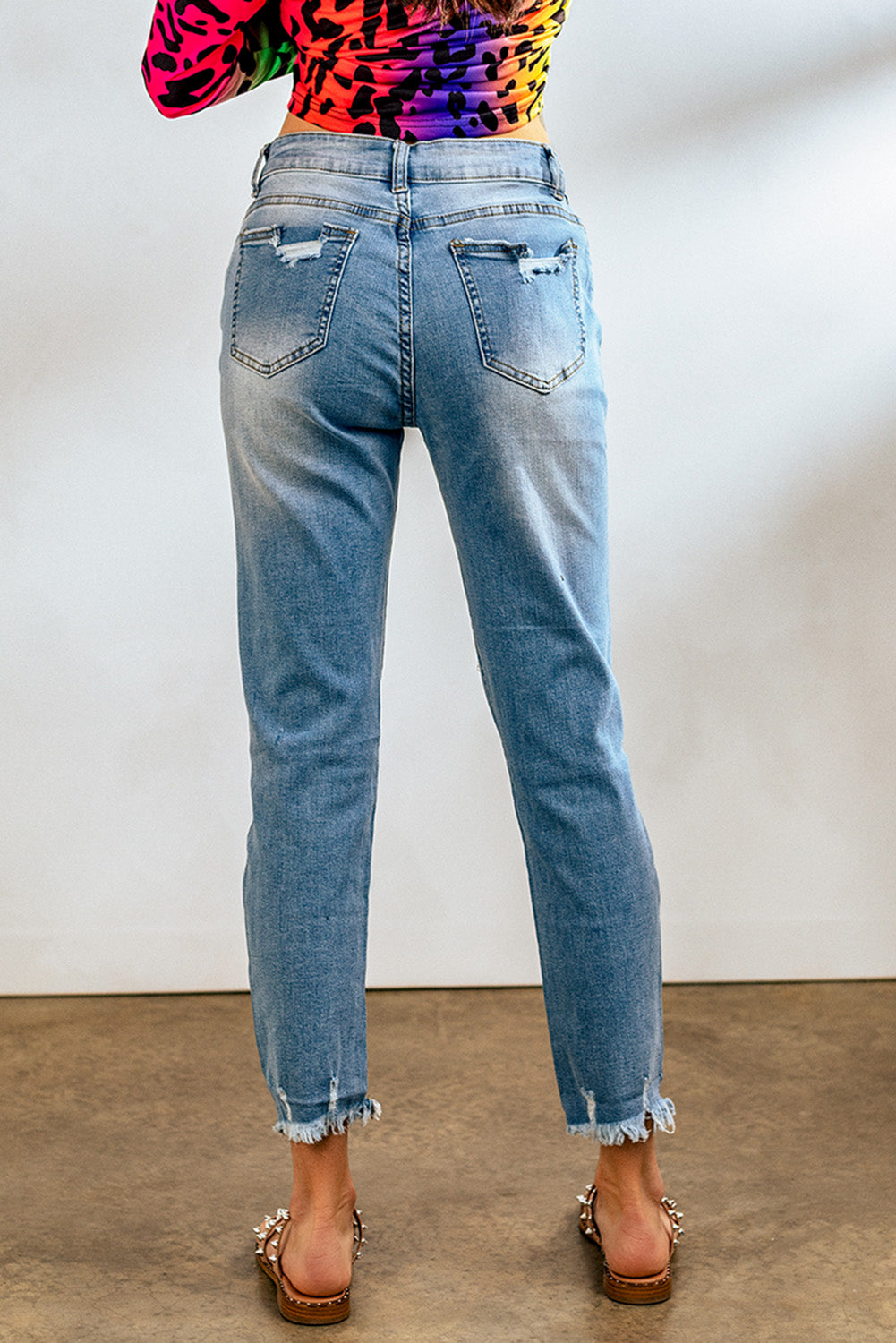 Light blue distressed boyfriend denim pants with a medium rise fit and straight leg silhouette, featuring classic five-pocket styling.