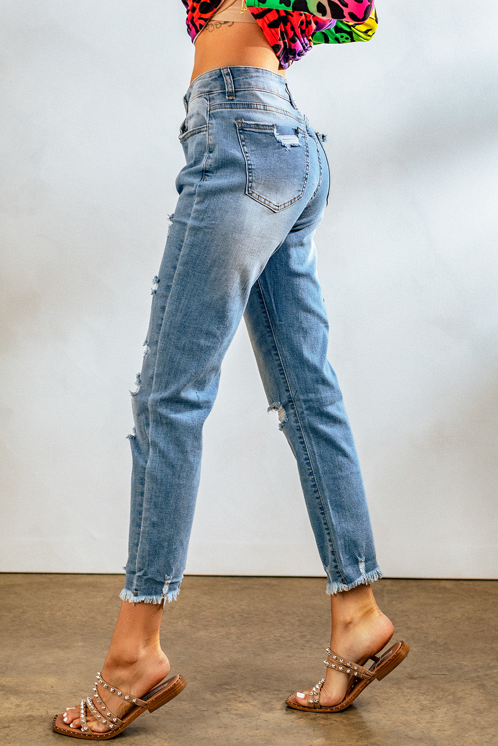 Light blue distressed boyfriend denim pants with a medium rise fit and straight leg silhouette, featuring classic five-pocket styling.