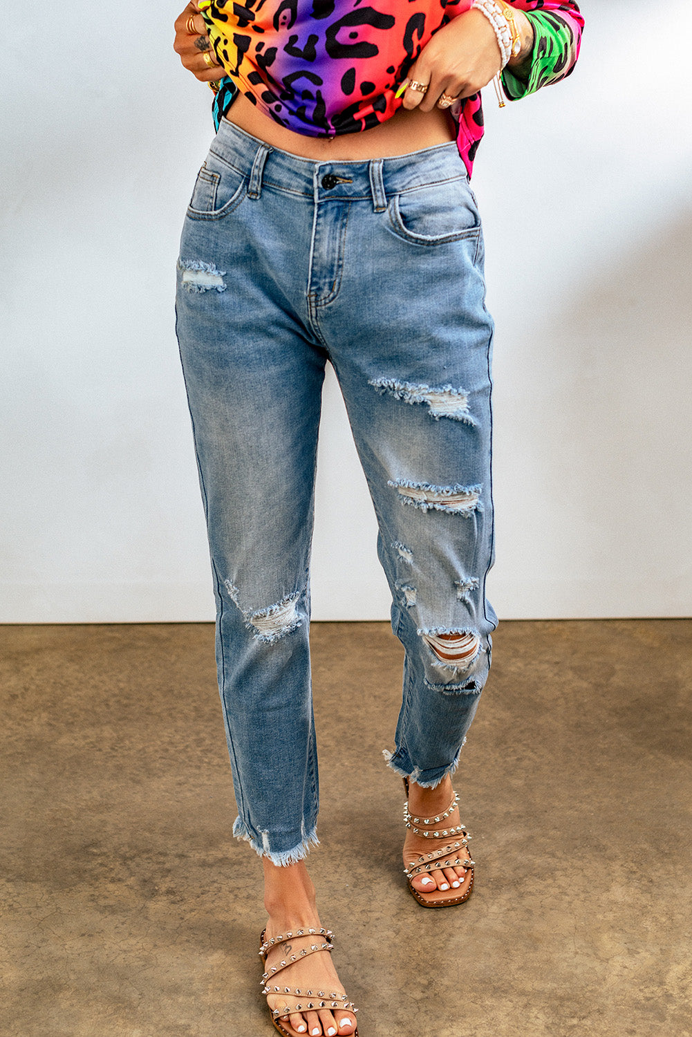 Light blue distressed boyfriend denim pants with a medium rise fit and straight leg silhouette, featuring classic five-pocket styling.