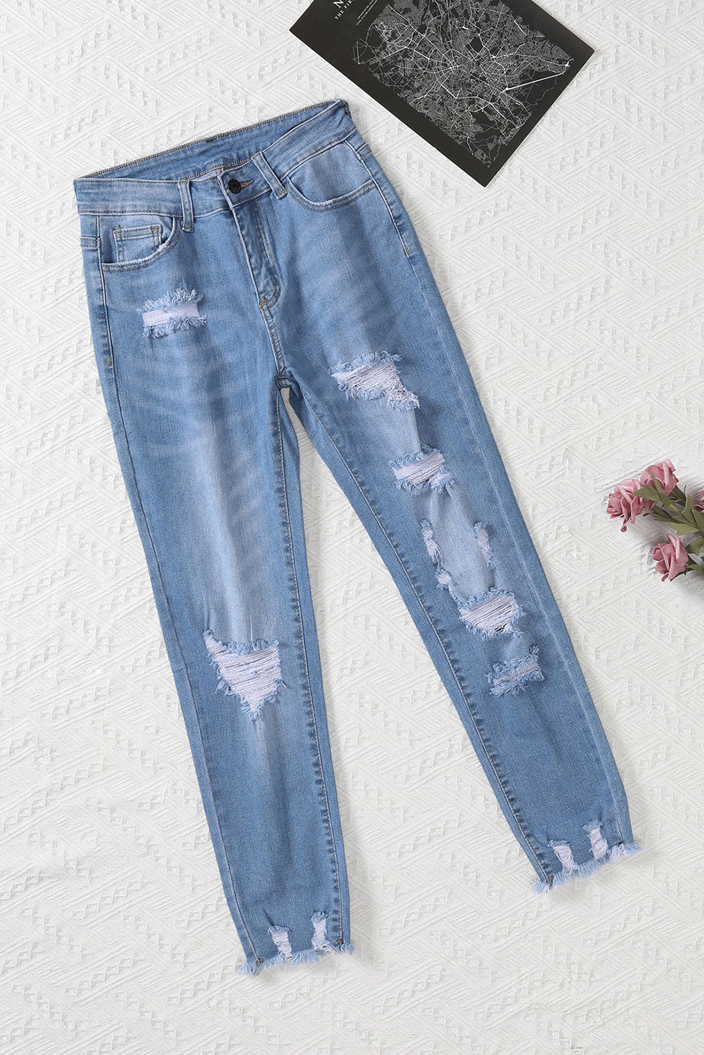 Light blue distressed boyfriend denim pants with a medium rise fit and straight leg silhouette, featuring classic five-pocket styling.