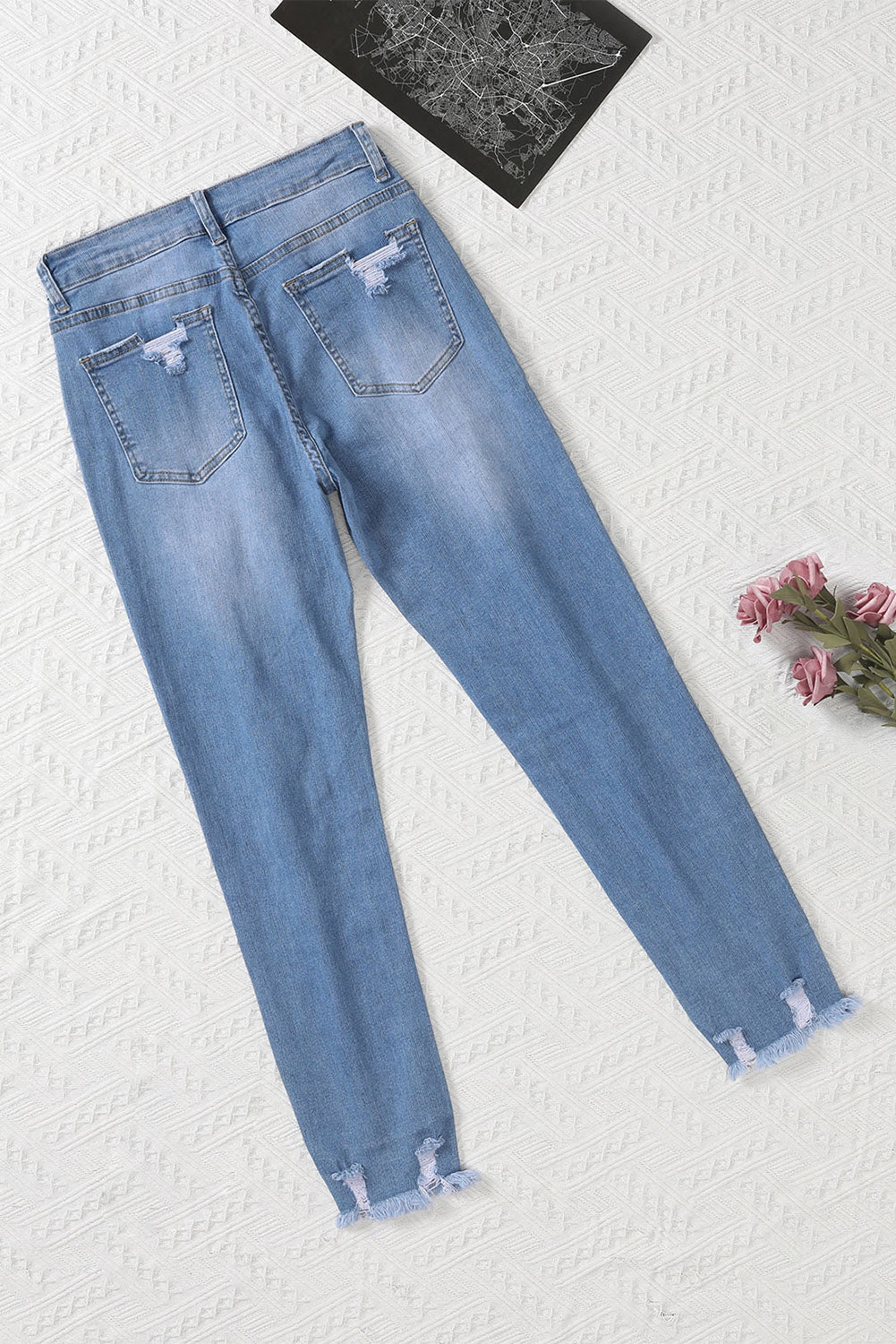 Light blue distressed boyfriend denim pants with a medium rise fit and straight leg silhouette, featuring classic five-pocket styling.