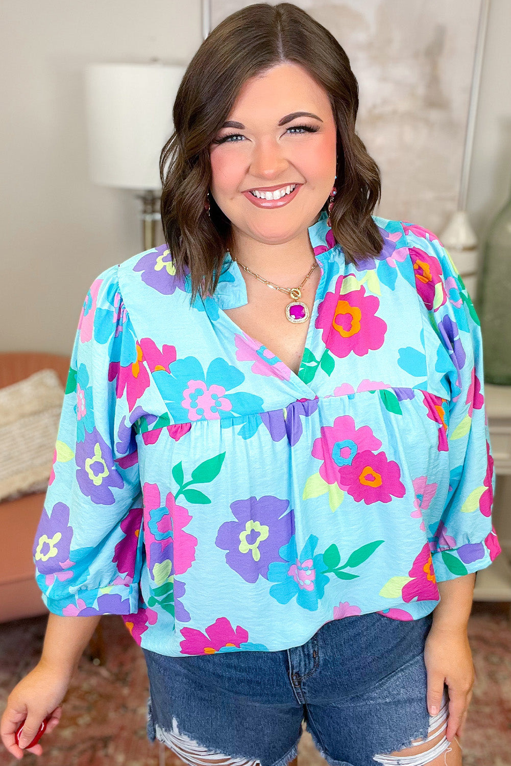 Light blue plus size floral print babydoll blouse with notched V-neck design, showcasing a stylish and comfortable fit.