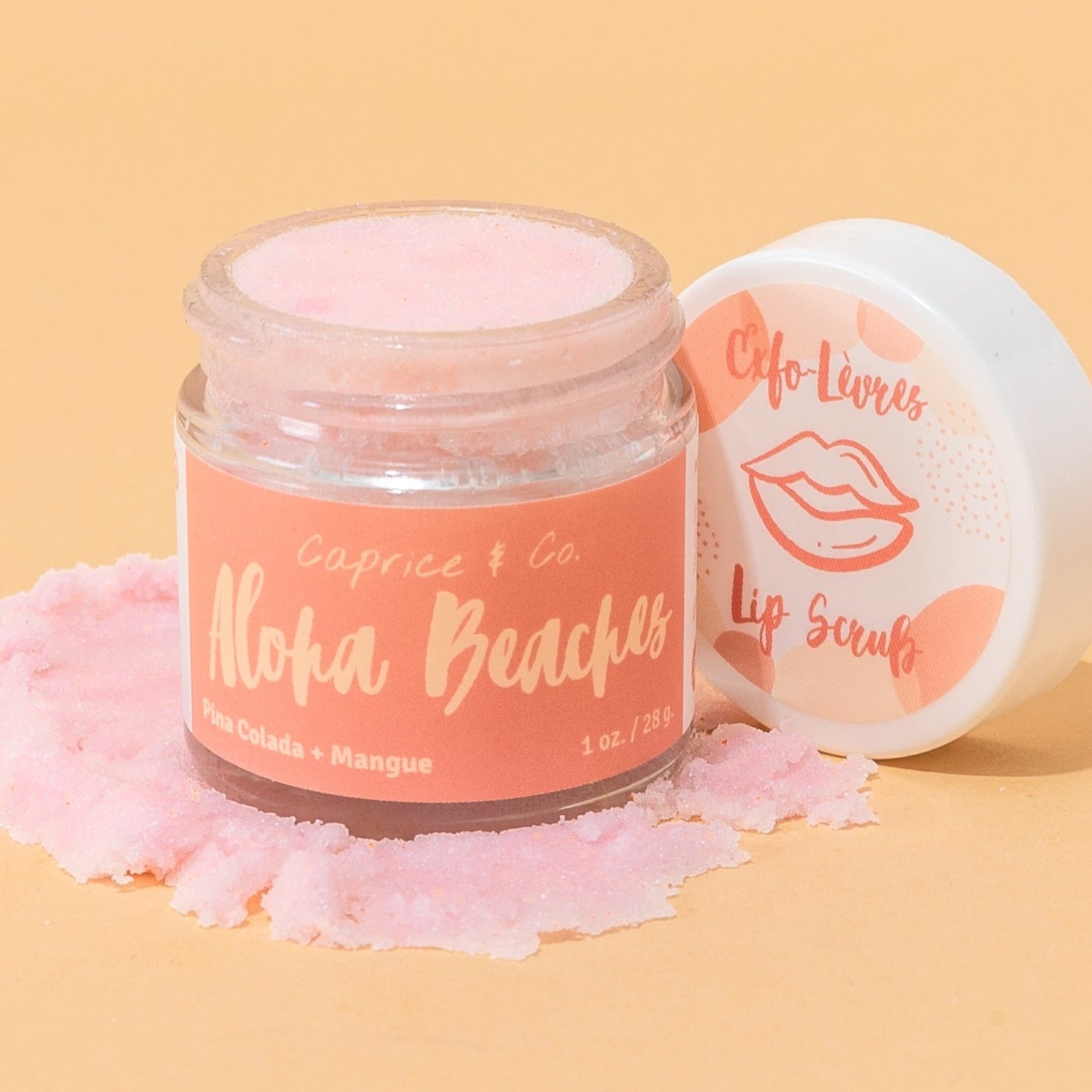 Aloha Beaches Lip Scrub in a jar, featuring tropical Pina Colada and Mango flavors, with a smooth texture and vibrant colors.