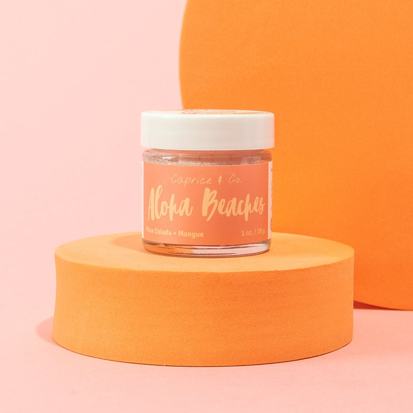 Aloha Beaches Lip Scrub in a jar, featuring tropical Pina Colada and Mango flavors, with a smooth texture and vibrant colors.