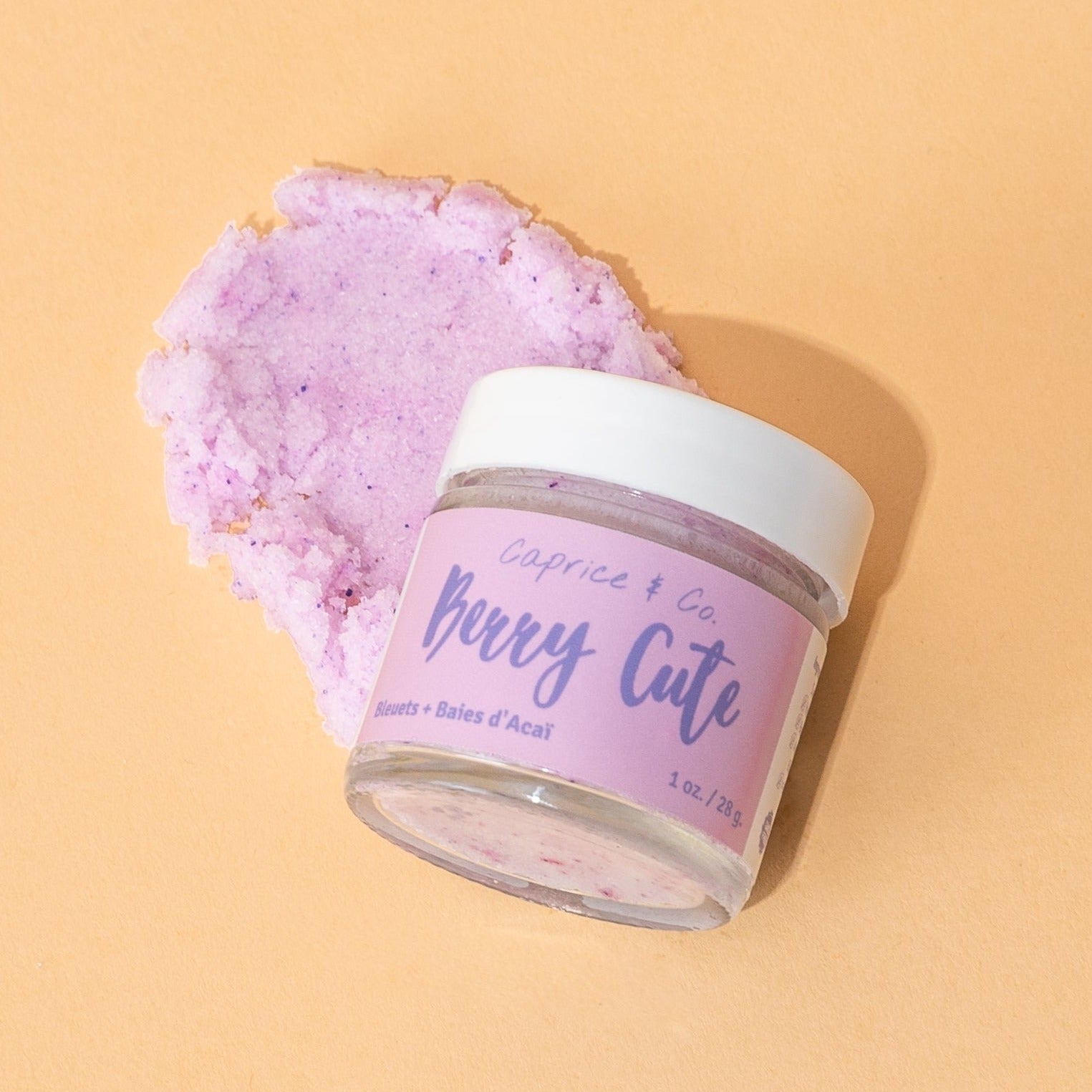 Berry Cute Lip Scrub in a jar with acai berries and blueberries, showcasing its natural ingredients and vibrant color.