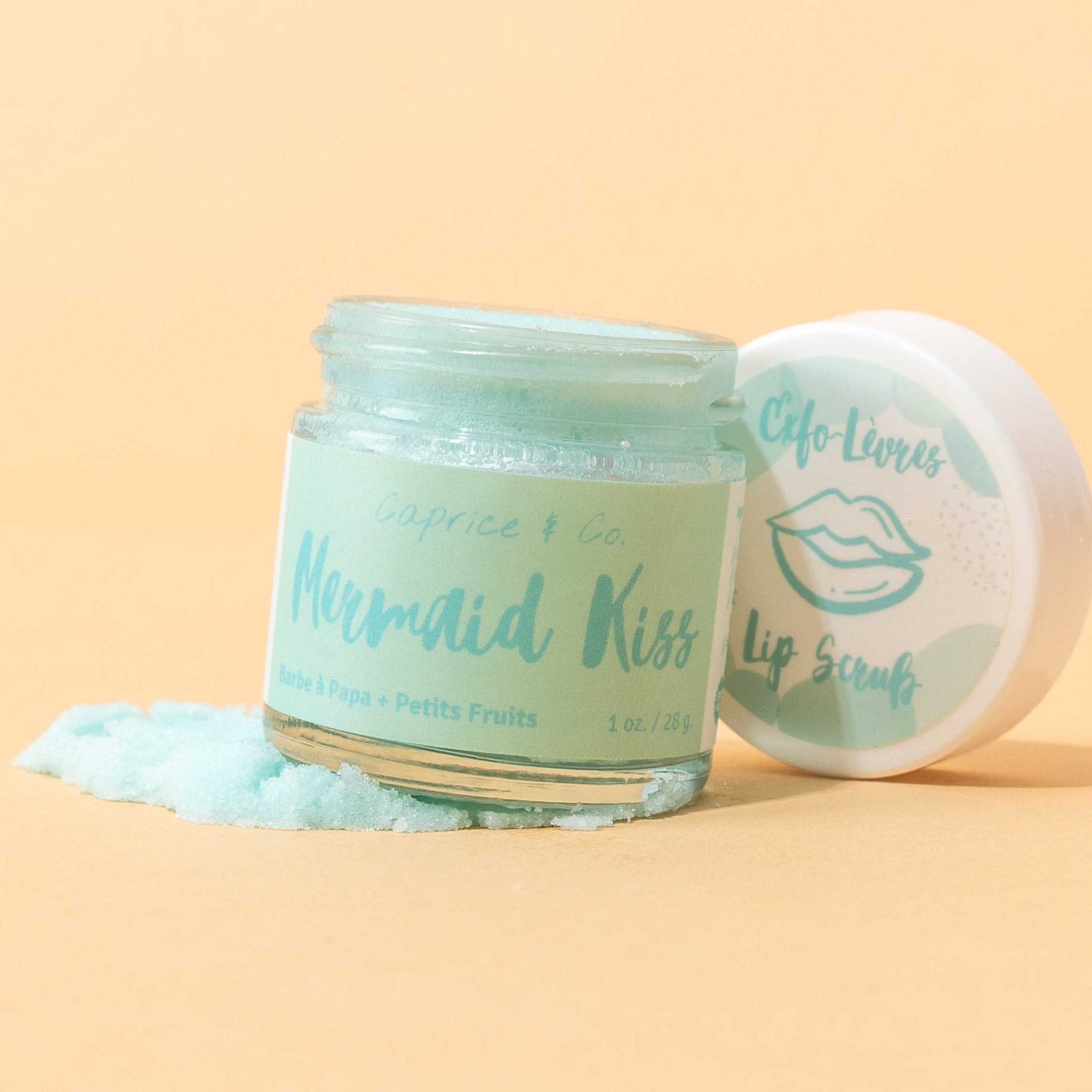 Mermaid Kiss Lip Scrub in a jar, featuring a vibrant cotton candy and berry color, with a spoon beside it for application.