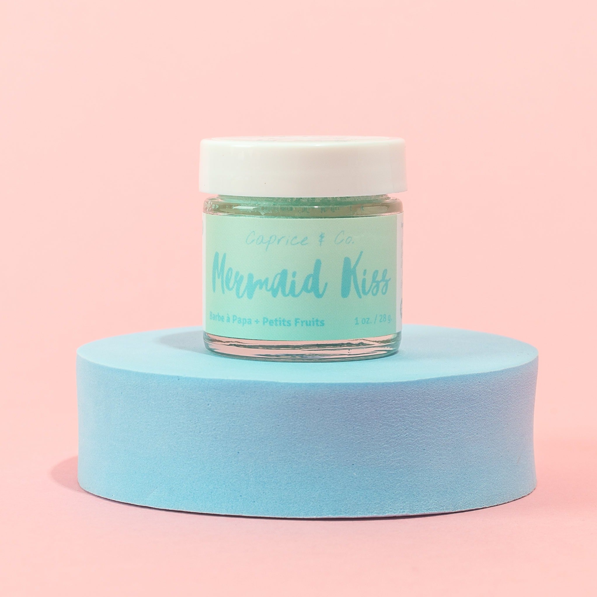 Mermaid Kiss Lip Scrub in a jar, featuring a vibrant cotton candy and berry color, with a spoon beside it for application.