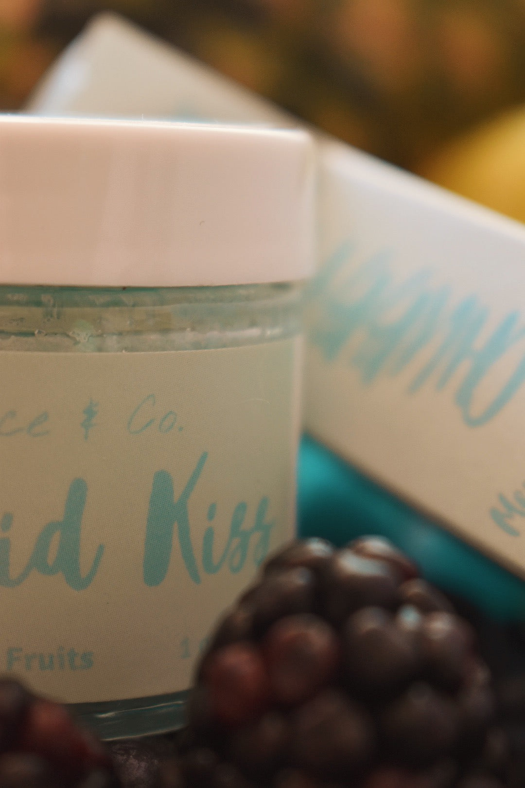 Mermaid Kiss Lip Scrub in a jar, featuring a vibrant cotton candy and berry color, with a spoon beside it for application.