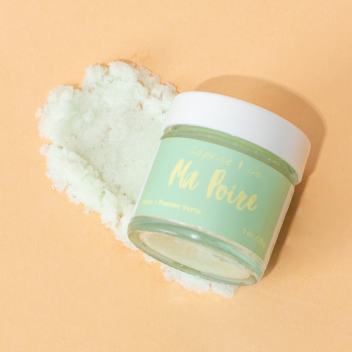 Ma Poire Lip Scrub in a jar with a pear and green apple flavor, showcasing its natural ingredients and handmade quality.