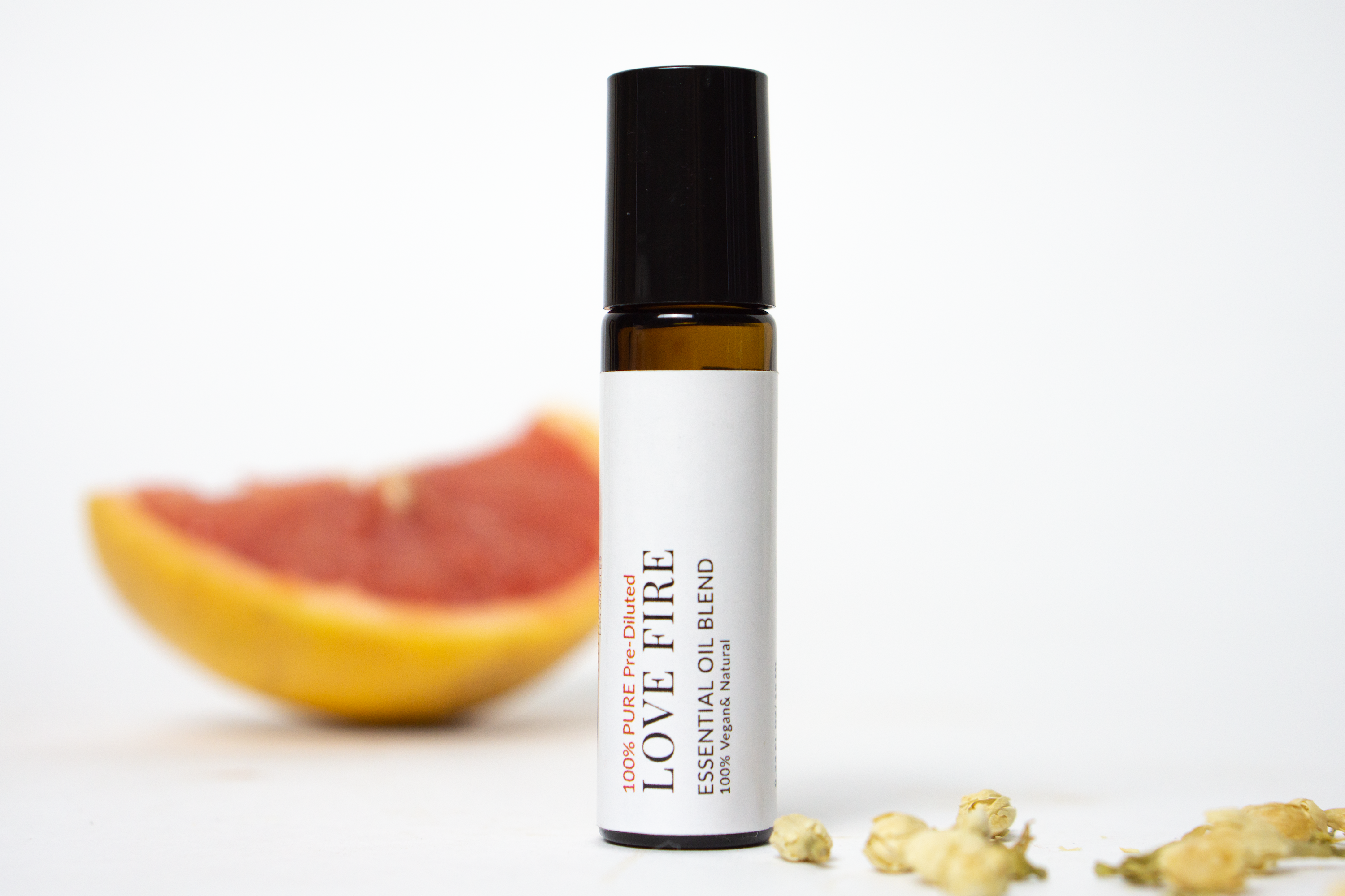 Love Fire Roll On Essential Oil Blend in a 10 mL bottle with a stainless steel rollerball, featuring a floral and woodsy scent.