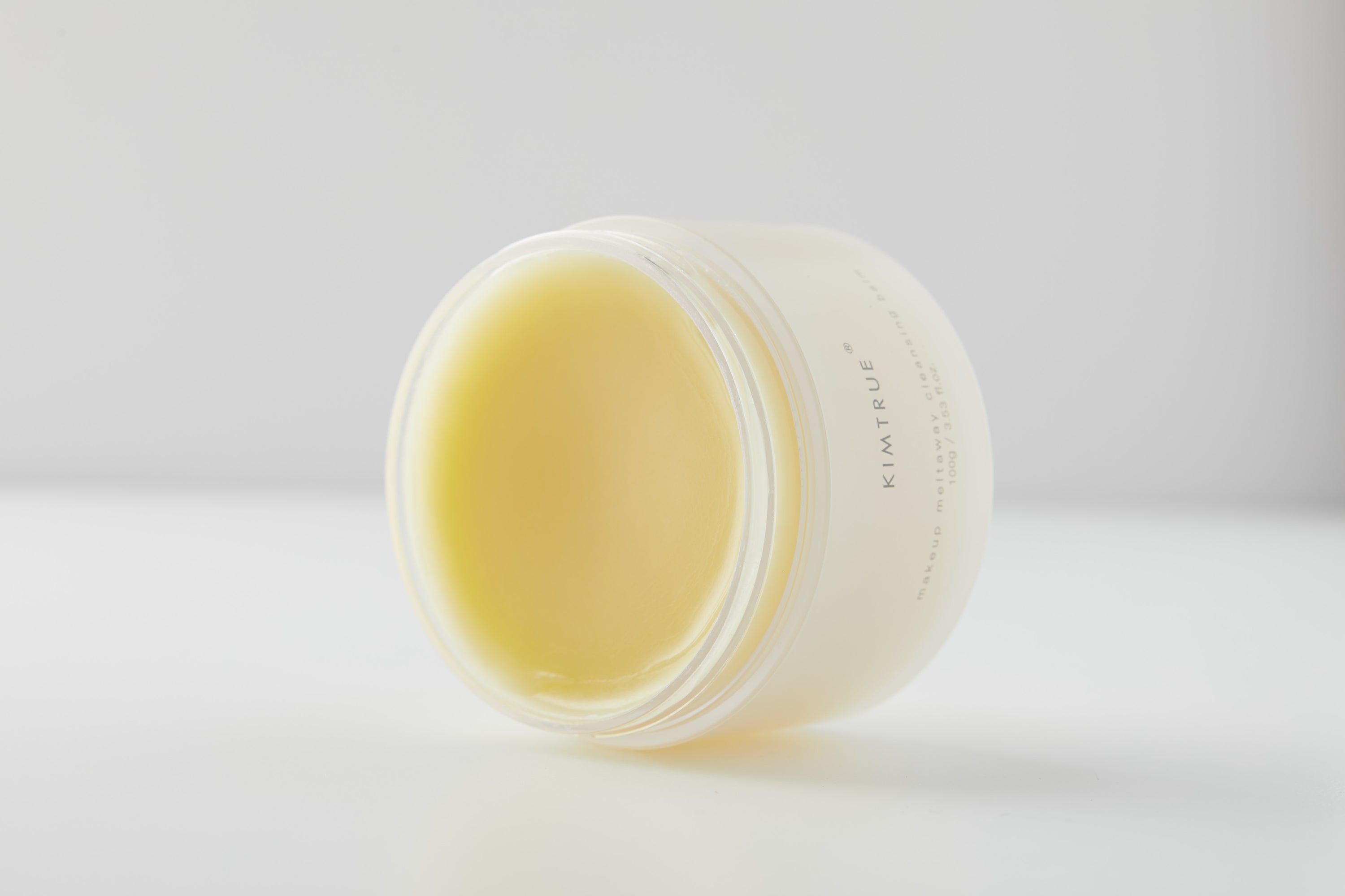 Makeup Meltaway Cleansing Balm in a sealed plastic container, showcasing its rich texture and natural ingredients like bilberry and moringa seed extracts.