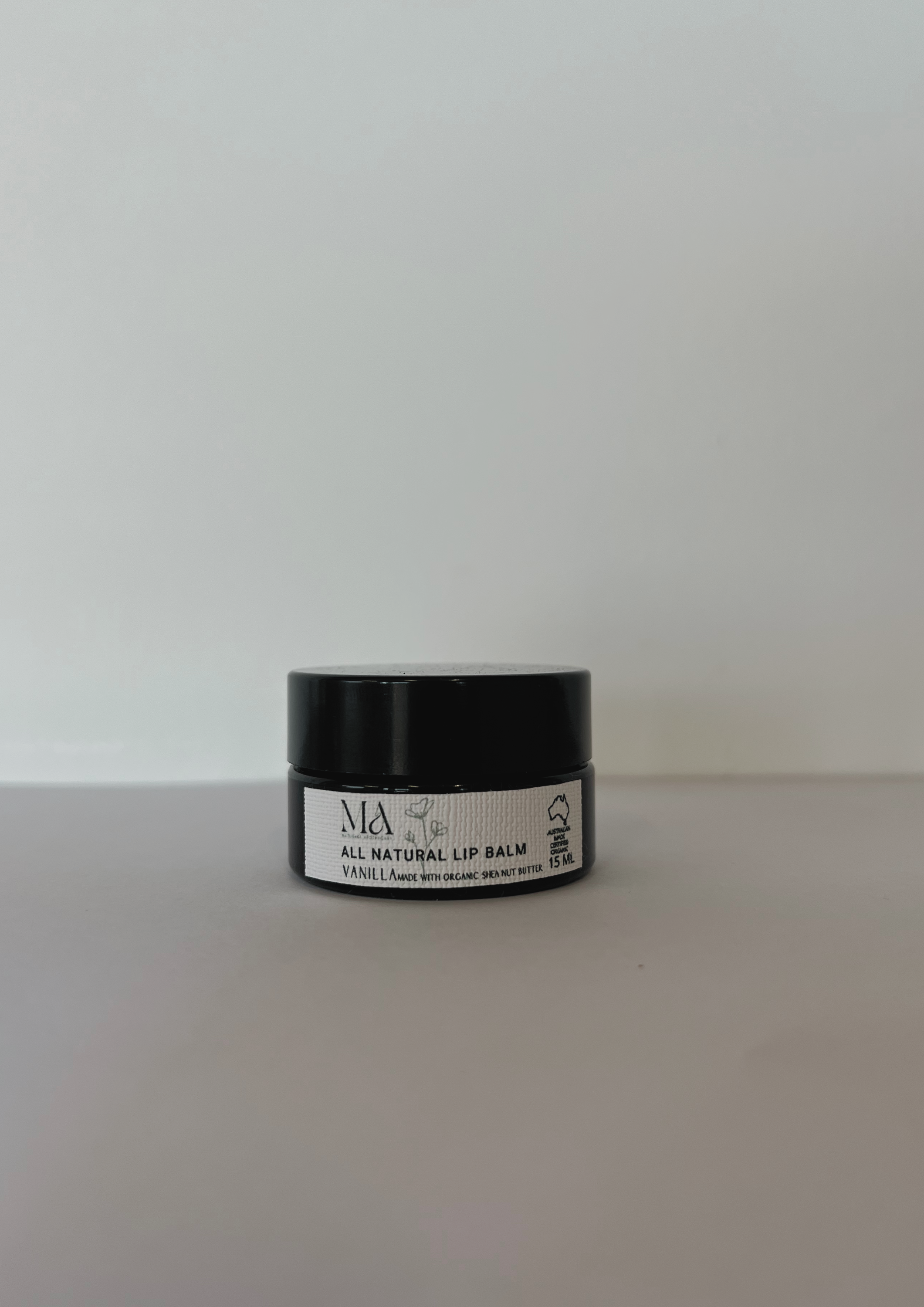 Matushka Miracle Organic Lip Balm in a stylish container with a natural vanilla scent, showcasing its organic ingredients.