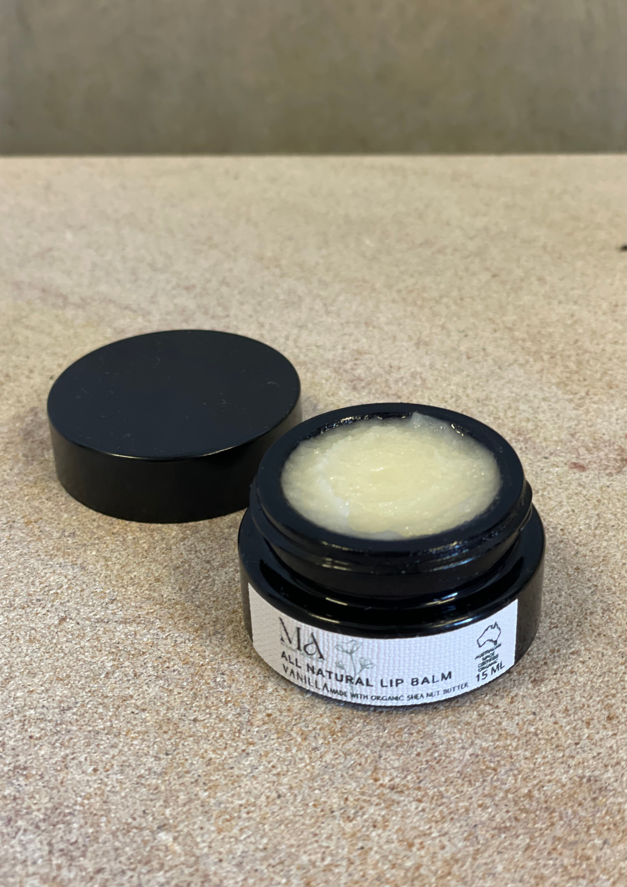 Matushka Miracle Organic Lip Balm in a stylish container with a natural vanilla scent, showcasing its organic ingredients.