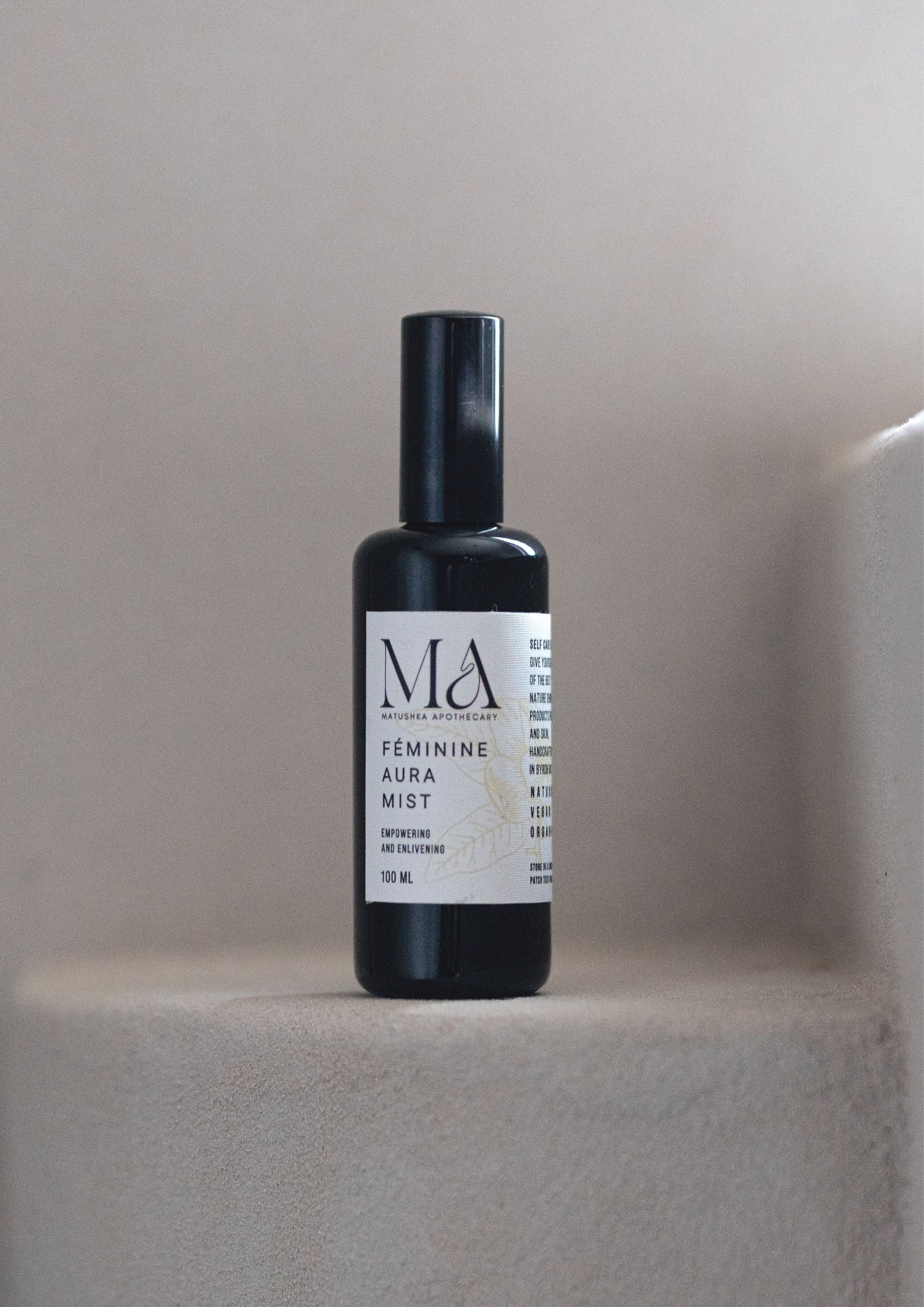 Matushka Organic Femininè Aura Mist in a black miron glass bottle, showcasing its elegant design and natural ingredients.